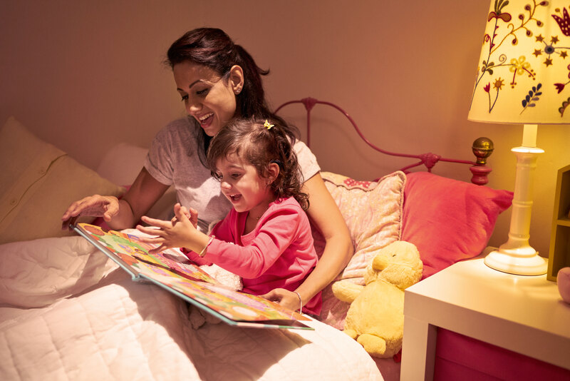 A child wearing an implant listens to her mother read a book