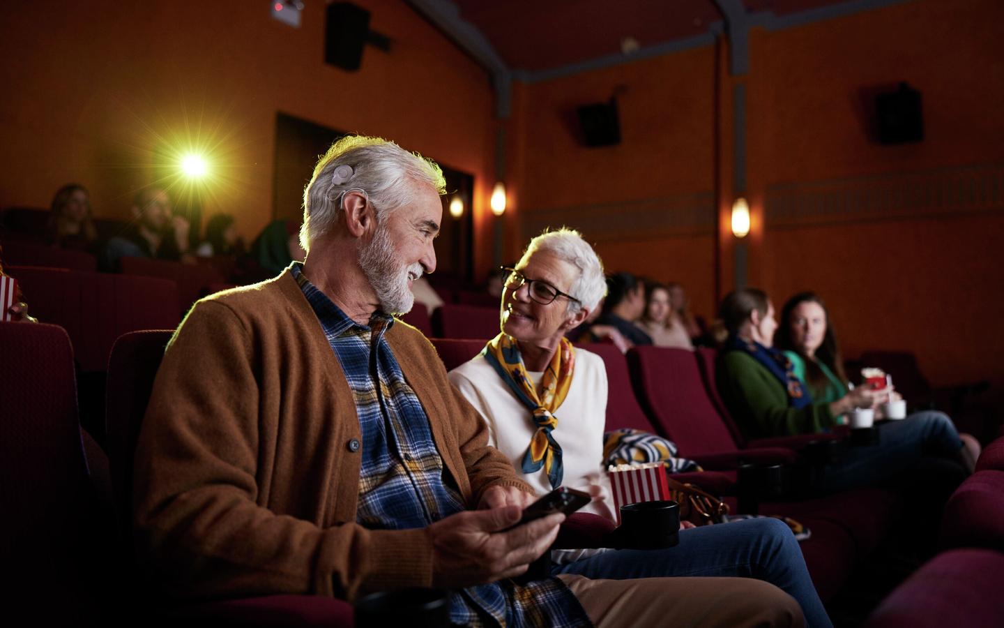 Two elderly people together in a cinema