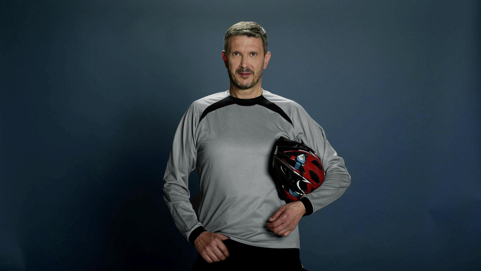 Carina implant recipient Alexandre holds his helmet as he poses for a photo