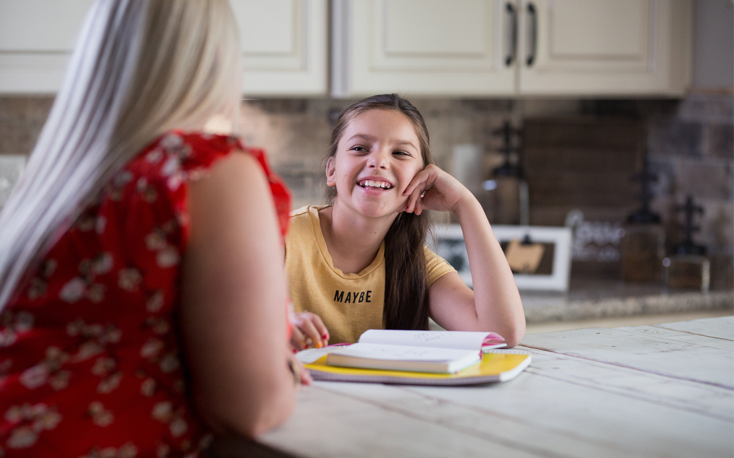 Holly, paciente con un sistema Cochlear, hace los deberes en la cocina con su madre