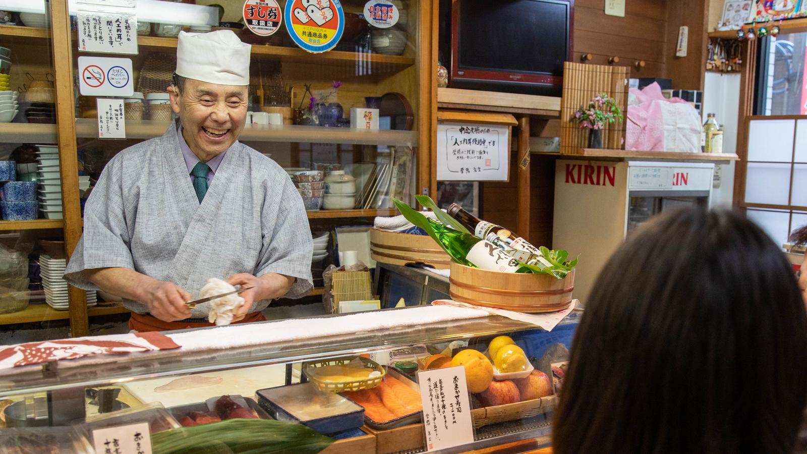 A man wearing an implant works in a sushi shop