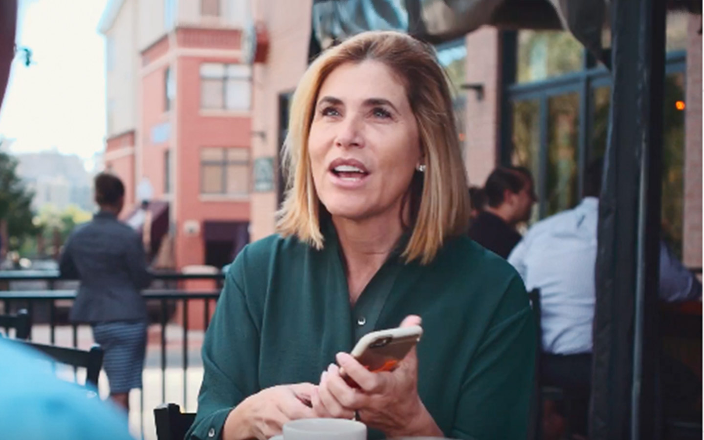 Cochlear recipient talks to a friend at a cafe