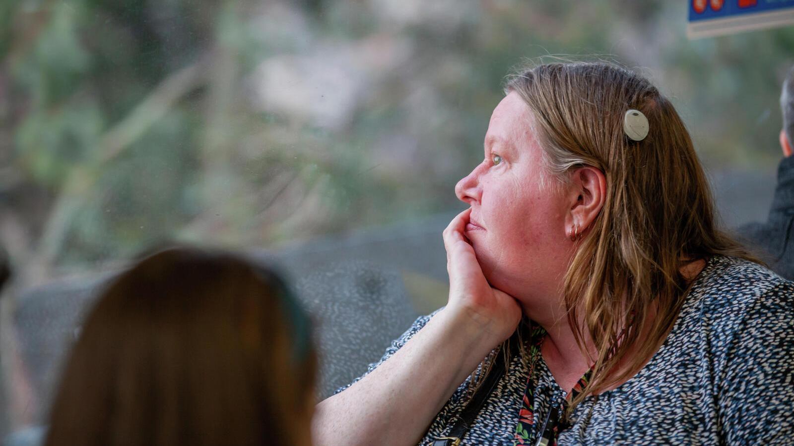 Woman with implant looks out of the window