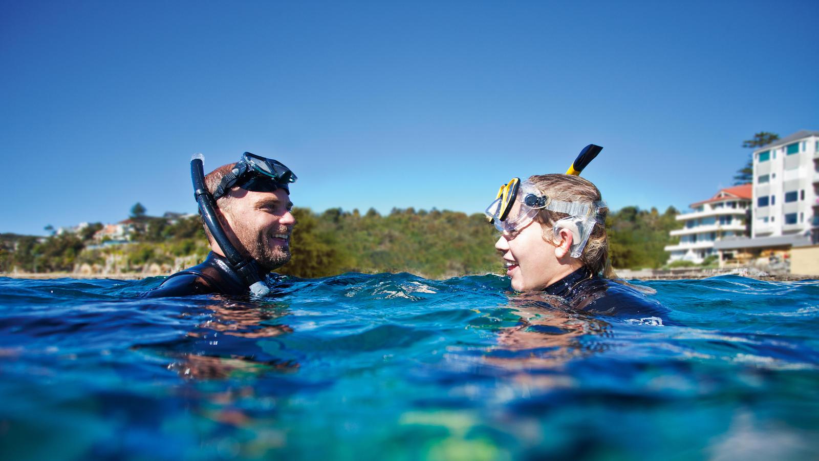 En mann med sitt Nucleus cochleaimplantat og vannsikkert tilbehør snorkler i vannet
