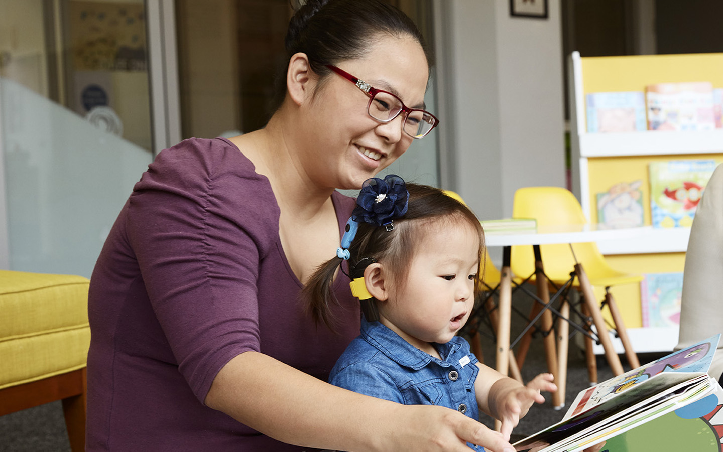 A woman reads a book to her child