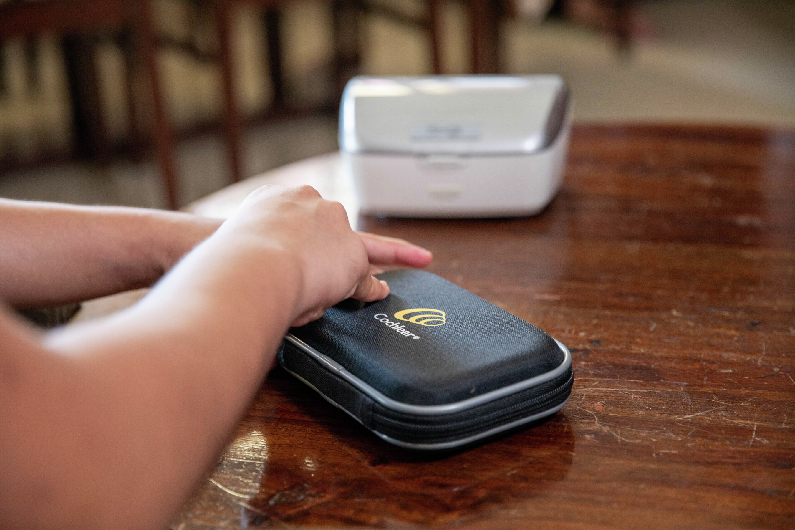 Adult man watching soccer on TV with Cochlear Wireless TV Streamer