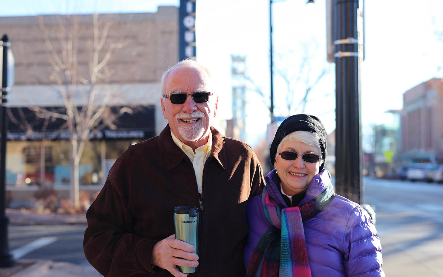 Cochlear-gebruiker Tom en zijn vrouw Brenda poseren op straat voor een foto