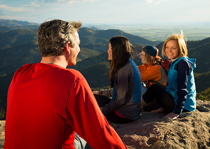 המושתל מתיאס ומשפחתו יושבים יחדיו על פסגת הר לאחר הטיול שלהם