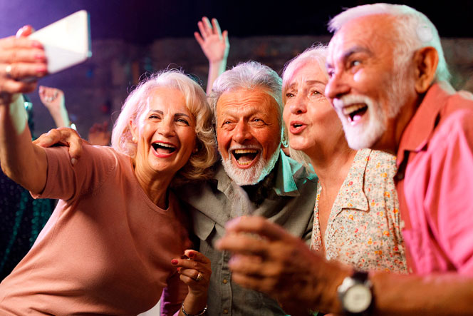 A group of people laughing while taking a selfie