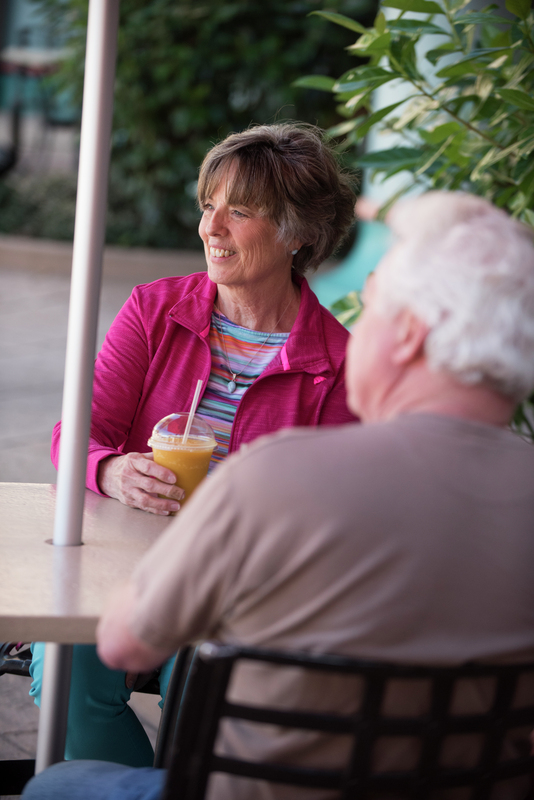 Couple sitting outside at a table drinking a juice