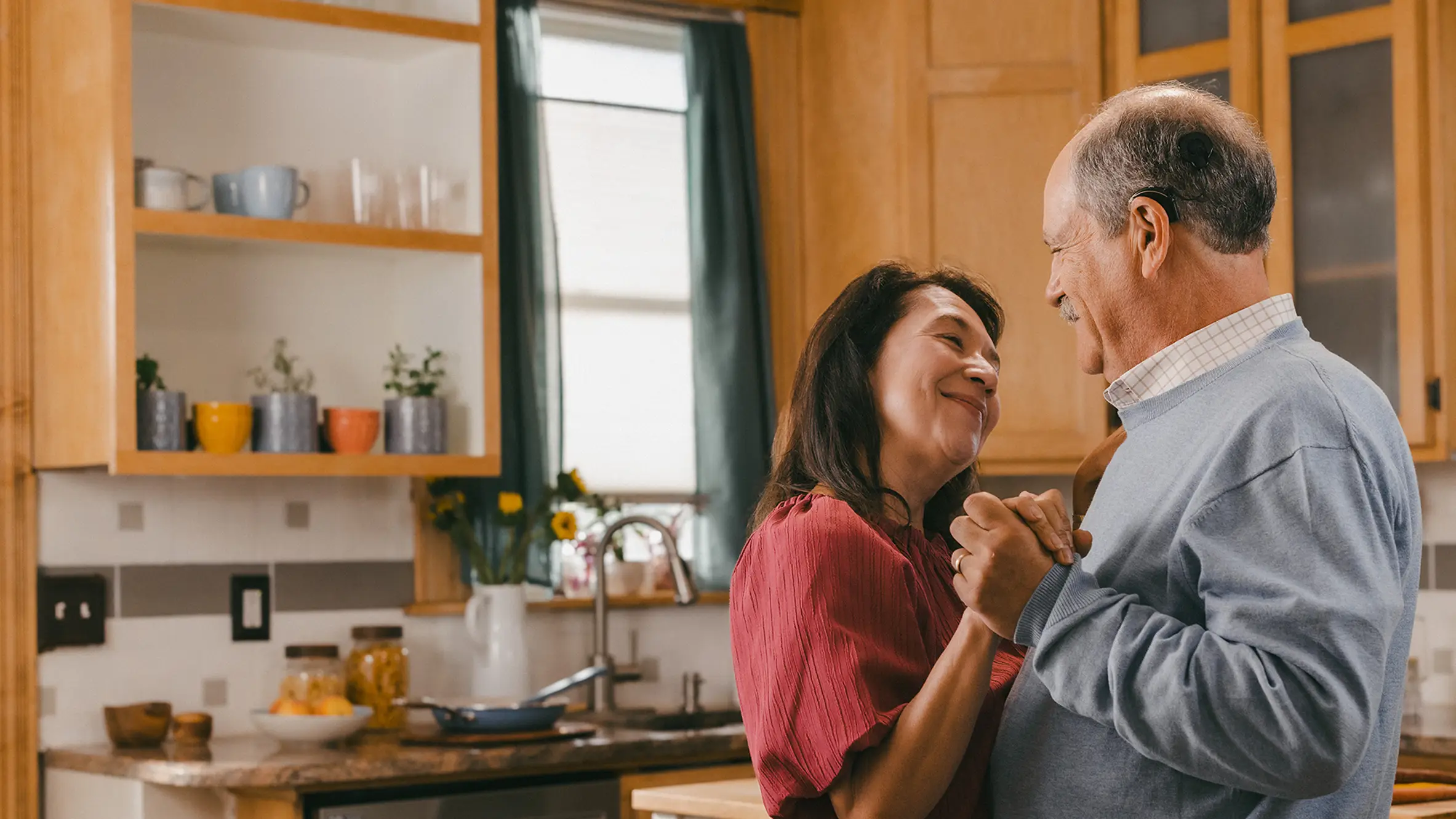A man wearing a Cochlear Implant Sound Processor dancing with a woman