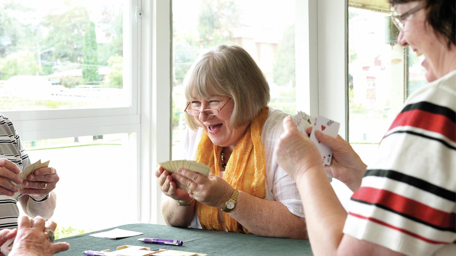 Donna, uživatelka systému Cochlear, se směje při hraní karet