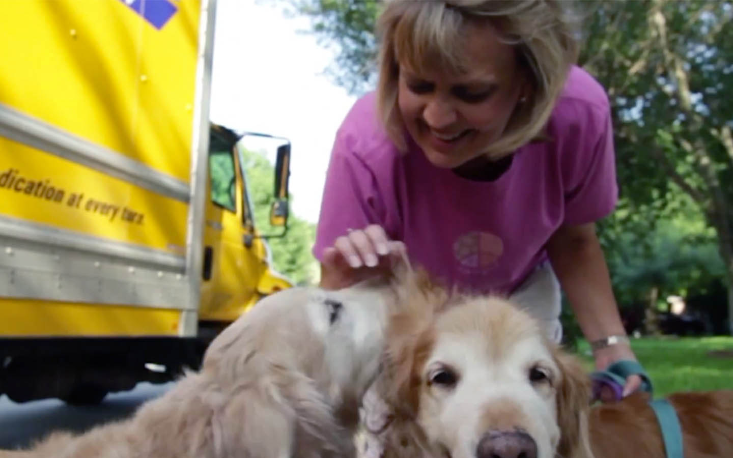 Recipient Deb pats her dogs as they go for a walk