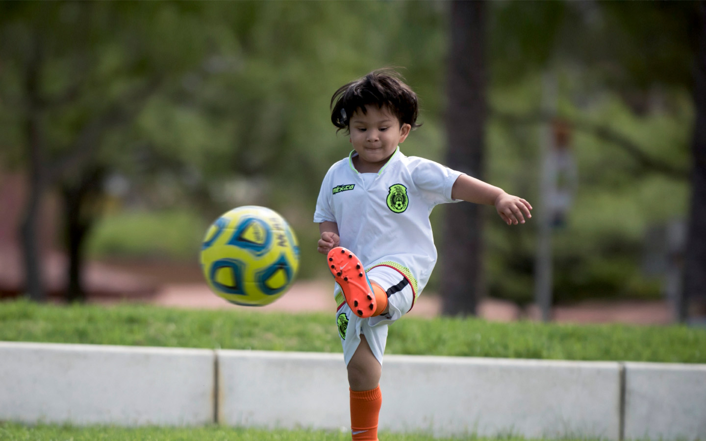 Baha-puheprosessoria käyttävä lapsi pelaa jalkapalloa
