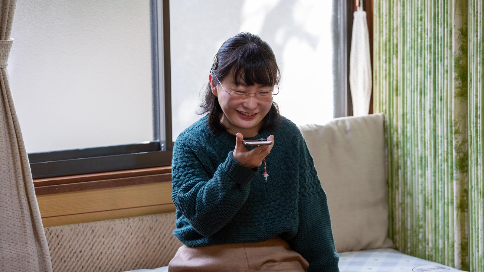 A woman wearing an implant speaks on a smartphone