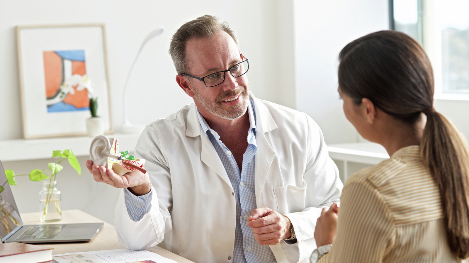 le patient discute de la procédure pour son implant cochléaire avec le chirurgien