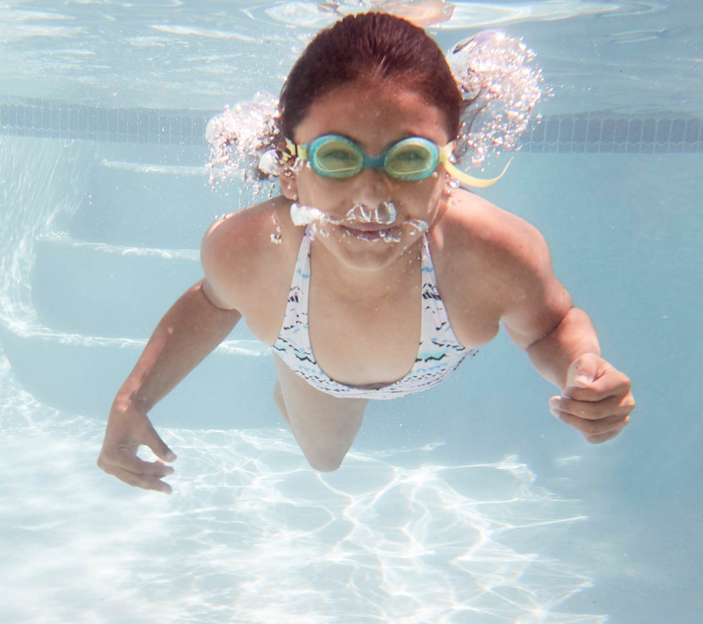 Kind die onderwater zwemt met Cochlear-implantaat
