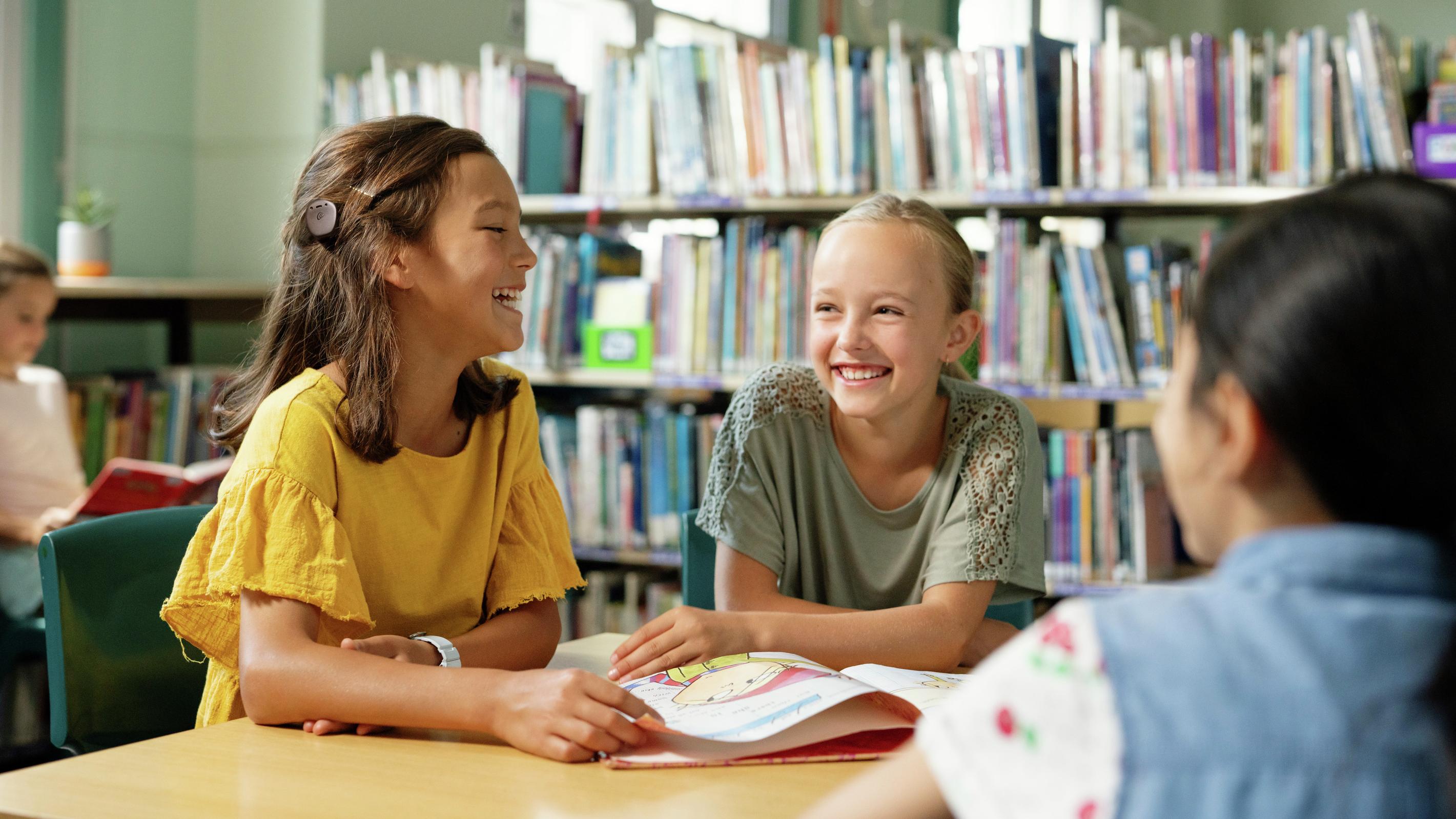 Three girls at school laughing with each