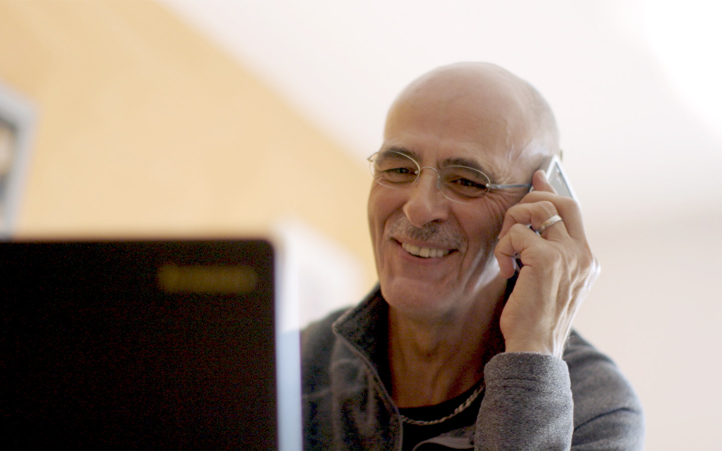 ein Mann telefoniert mit einer Person, die ebenfalls ein Cochlear Hörimplantat trägt 
