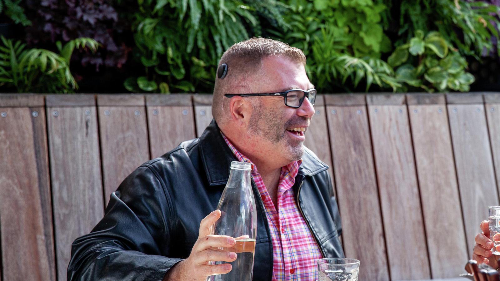 Three people sitting outside laughing and chatting