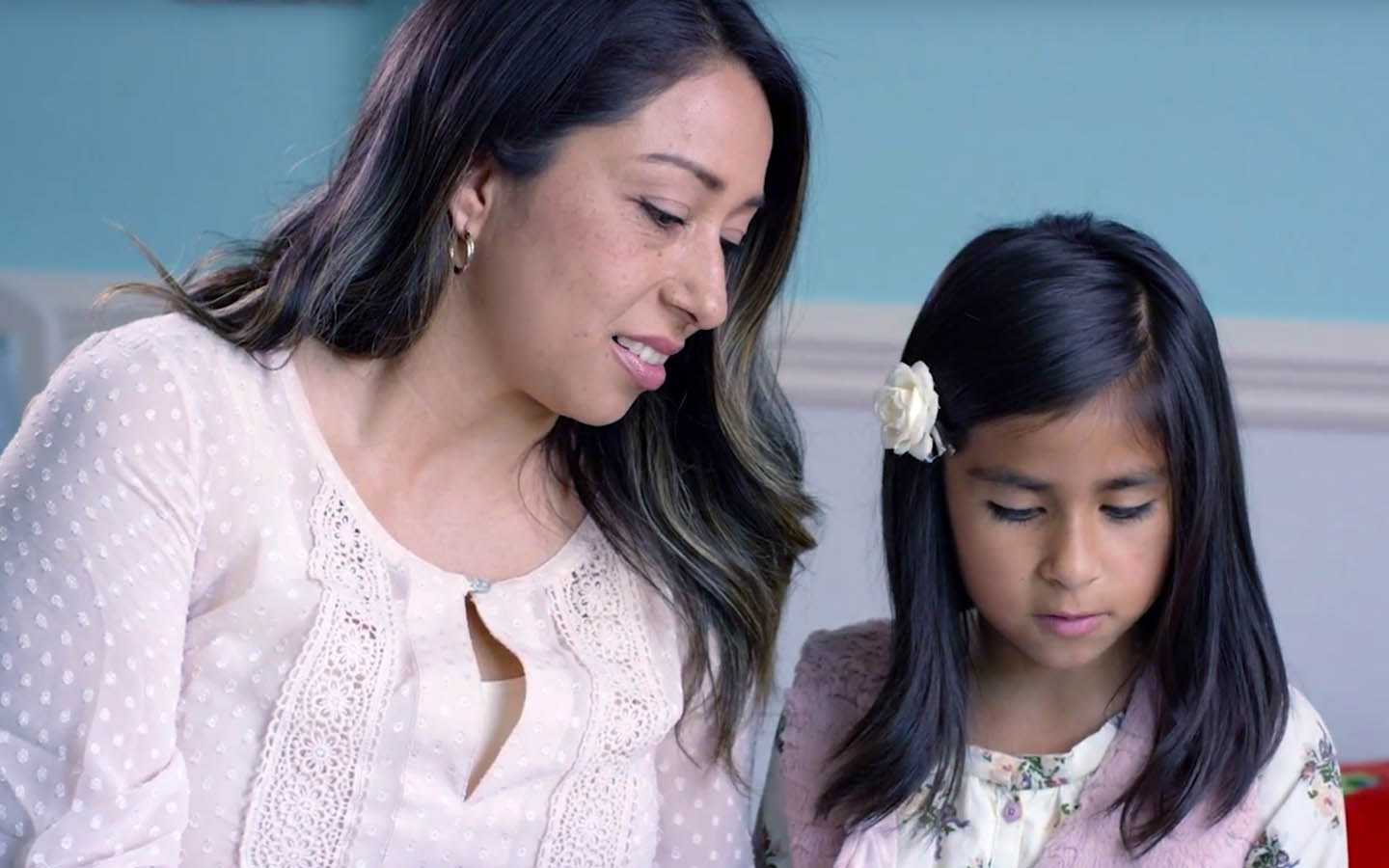 Cochlear implant recipient Phoebe reads a book with her mother Cynthia