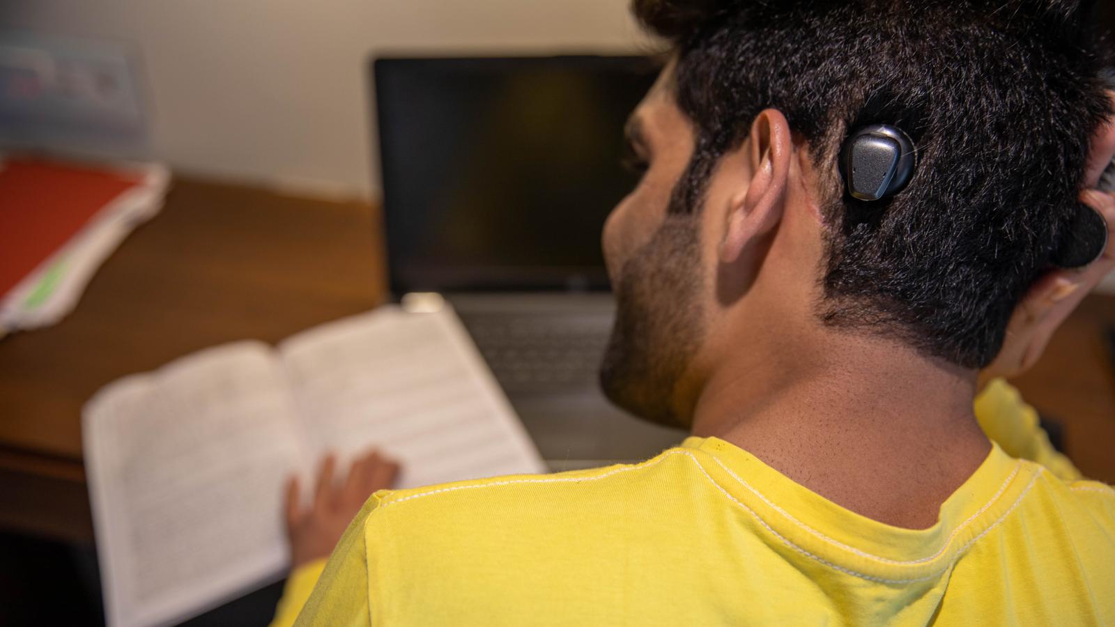 A bone conduction implant recipient chats with his grandchildren