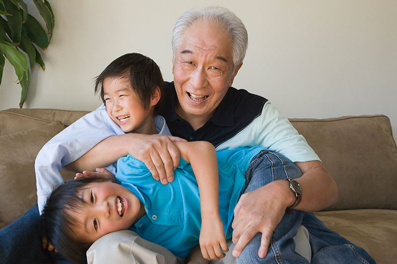 2 人の孫と遊ぶ祖父