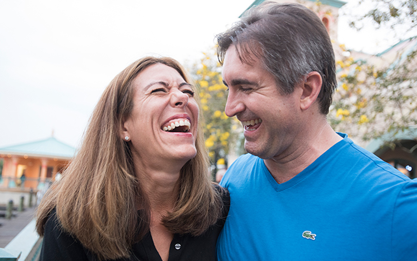 A wife and husband laughing together in the street