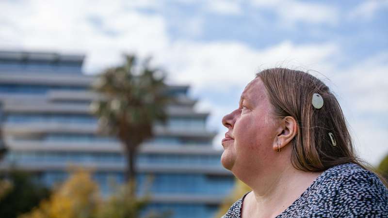 A woman wearing an Cochlear Osia Sound Processor
