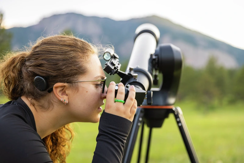 A woman looking through the lens of a camera