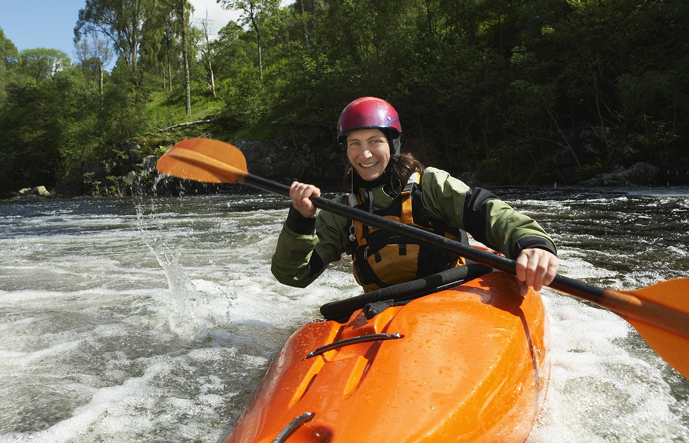 An adult wears a Cochlear Hybrid while kayaking