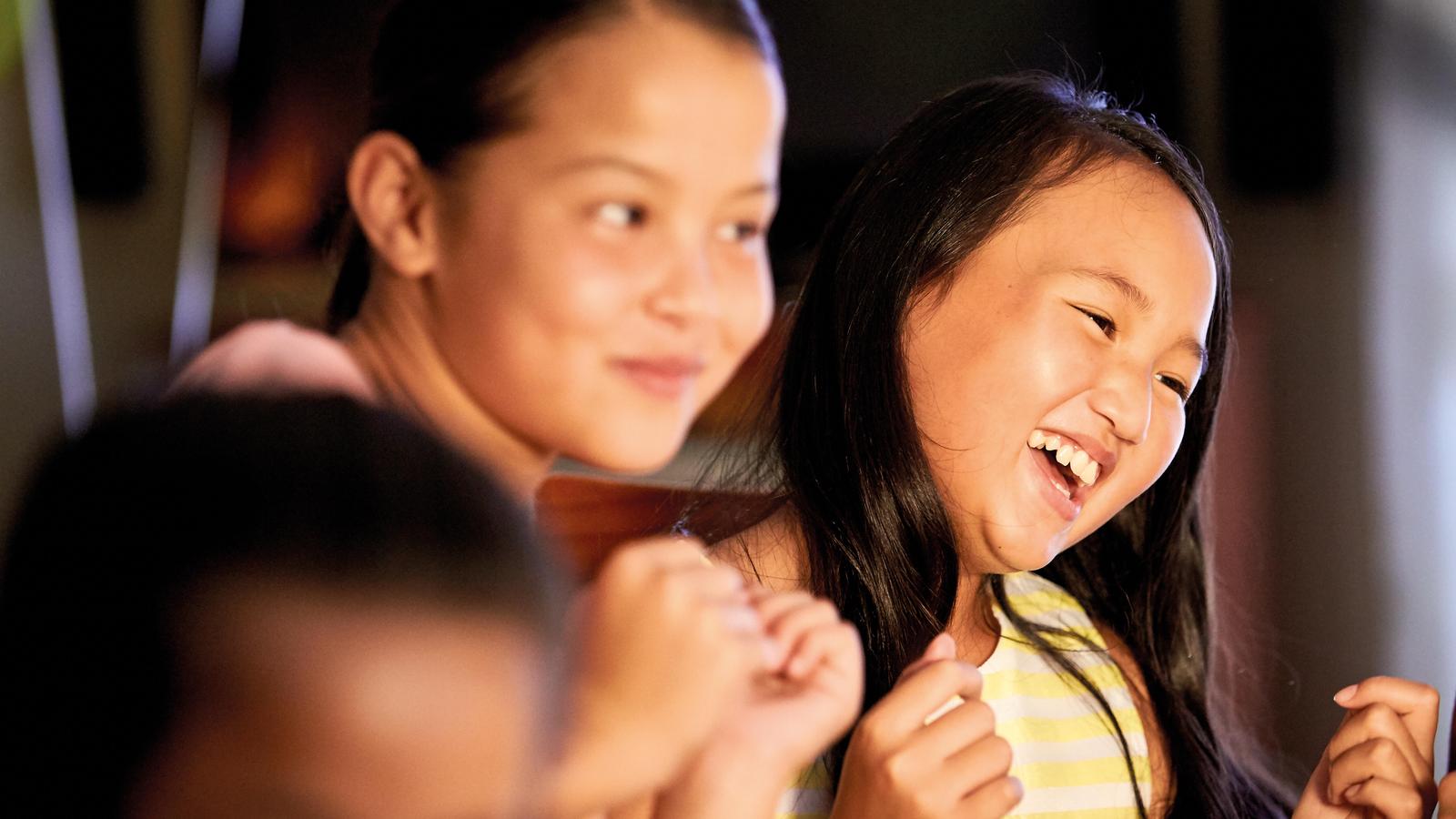 Two girls dance with friends during a birthday party