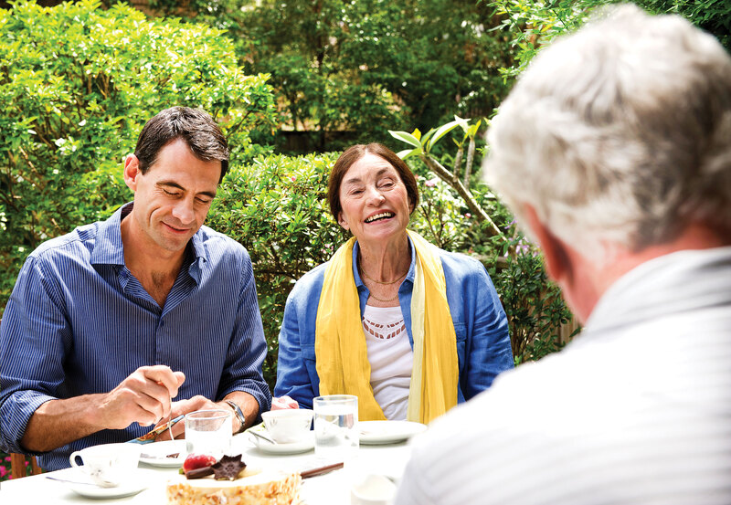 Drie volwassenen die samen eten in de tuin