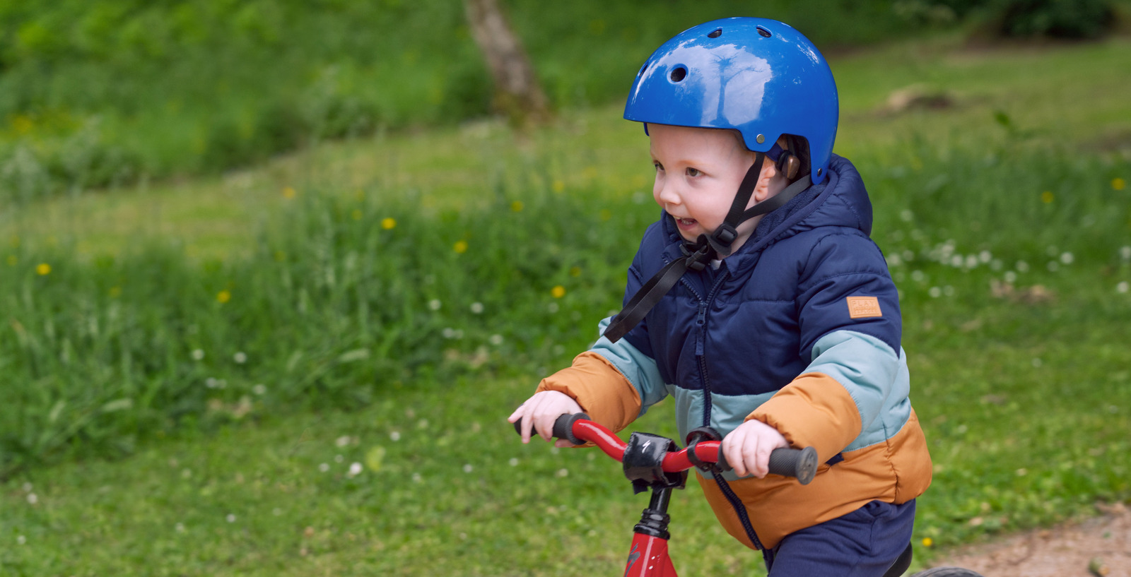 Young Baha Start recipient riding his bike. He's wearing his Baha Start solution underneath his helmet to have access to sound.