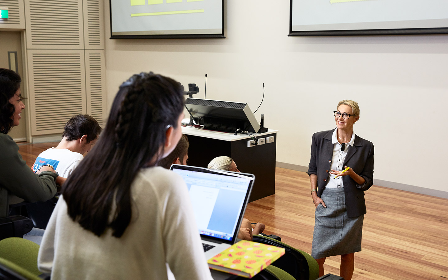 People in a lecture hall listen to a presentation