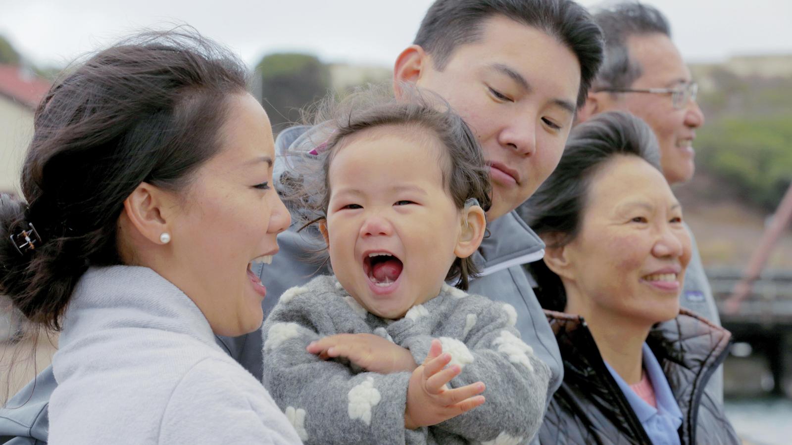Семья Су смеется во время прогулки на свежем воздухе