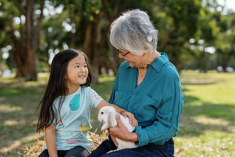 Smiling woman wearing a Cochlear hearing implant.