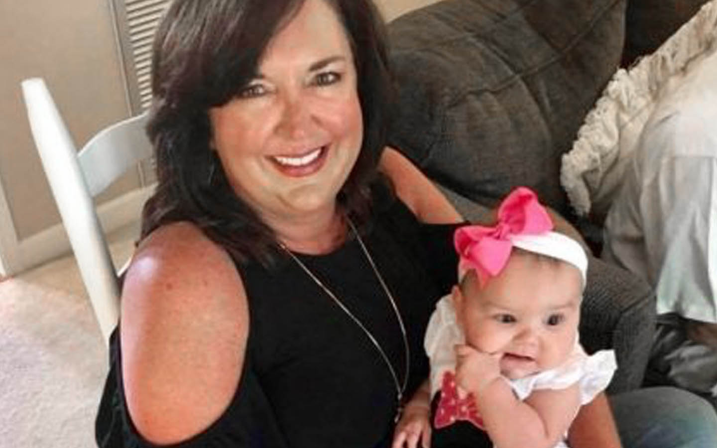 Angie, porteuse d’un implant, pose pour une photo avec un bébé