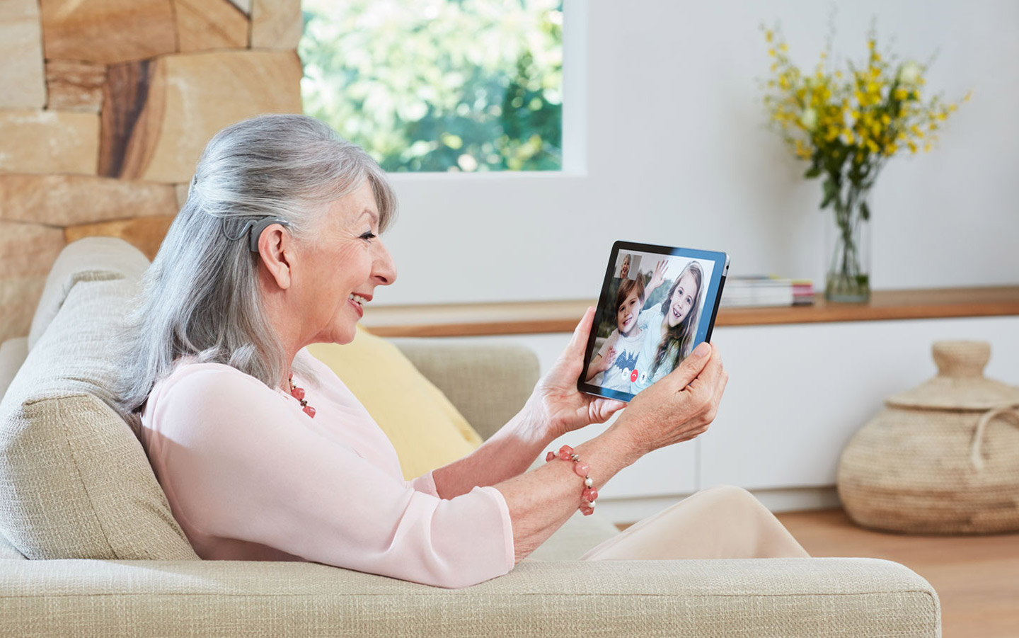 Une femme avec un implant cochléaire utilise un iPad