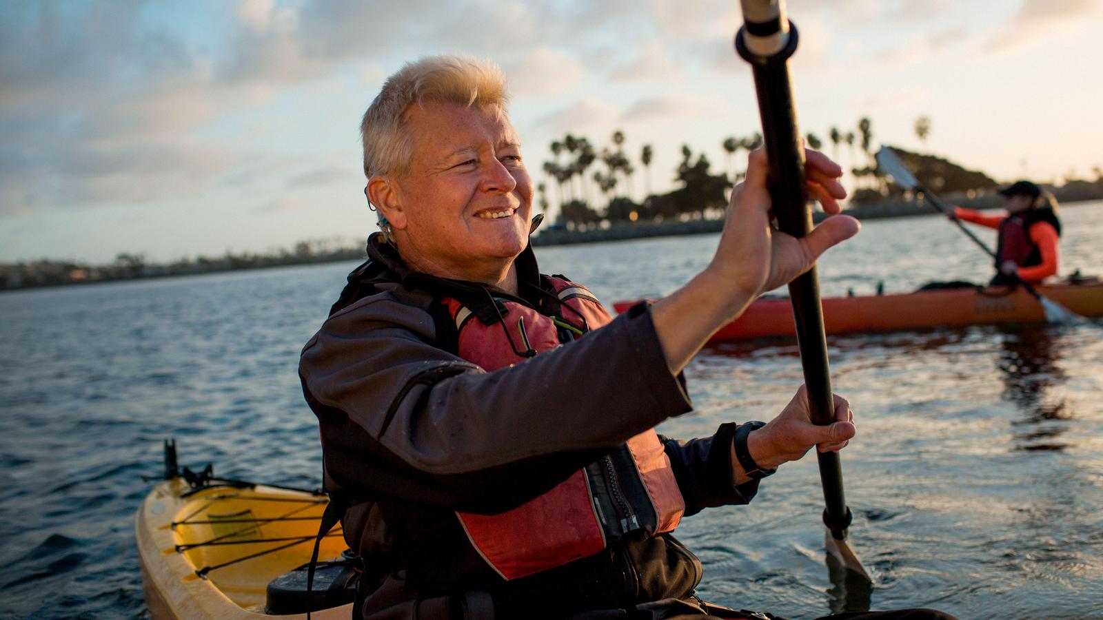 En mand, der bruger Nucleus vandtæt tilbehør uden på sit cochlear-implant, mens han sejler i kajak