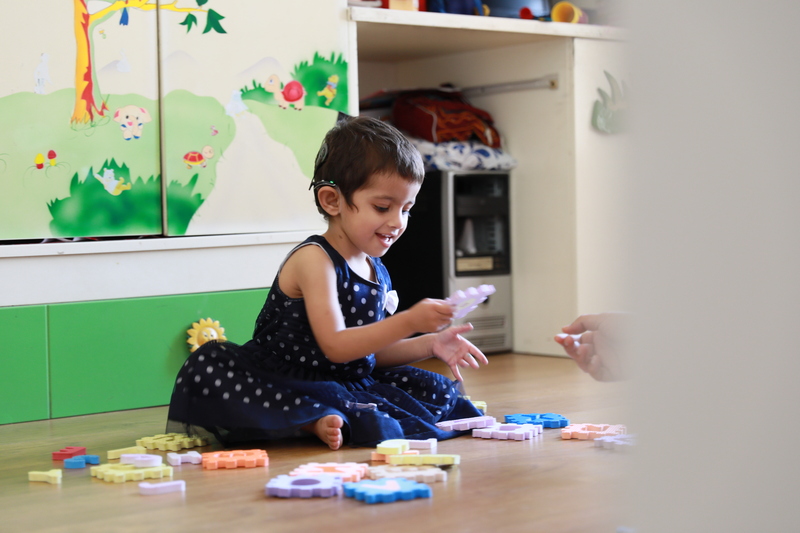 A young boy plays with a xylophone as a woman watches on