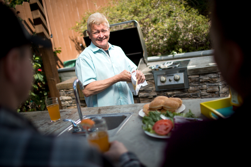 Een man lacht naar de camera tijdens een BBQ